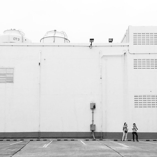 Gente de pie en la calle y fotografiando contra el edificio