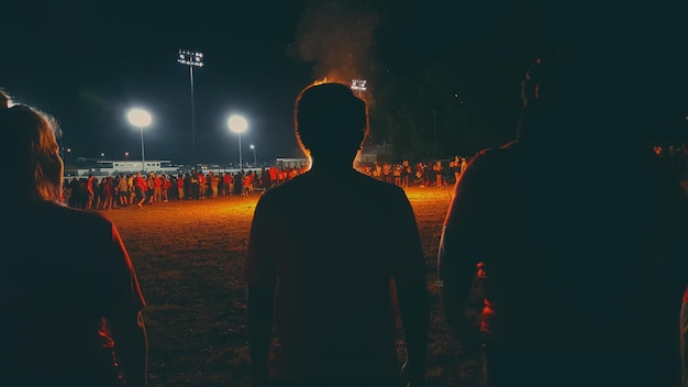 Foto la gente de pie en el campo por la noche