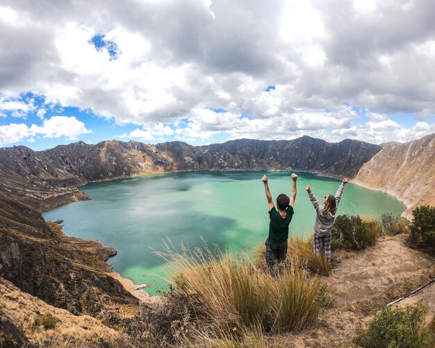 La gente de pie en la montaña contra el cielo