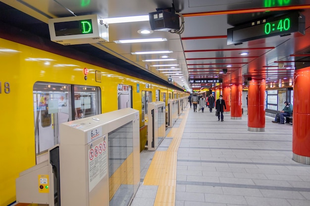 Foto gente en la plataforma de la estación de tren del metro en la estación de tokio