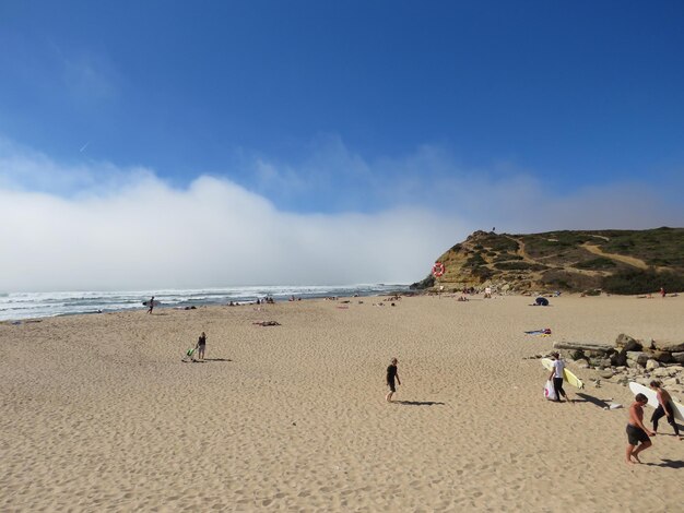 Foto la gente en la playa contra el cielo azul