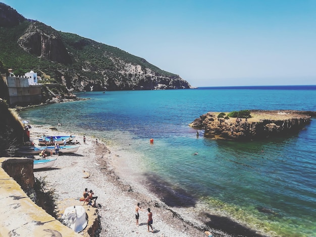 La gente en la playa contra el cielo despejado