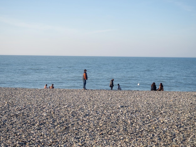 Gente en la playa de guijarros de primavera Vacaciones en la playa Relajación en el mar Costa rocosa