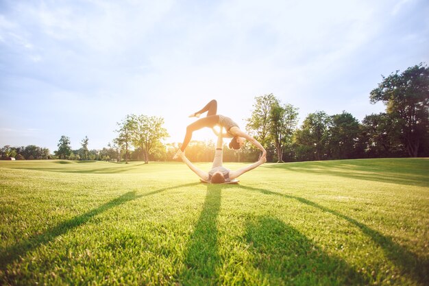 La gente practica acro yoga al aire libre estilo de vida saludable