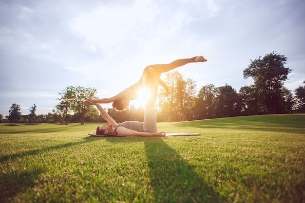 La gente practica acro yoga al aire libre estilo de vida saludable
