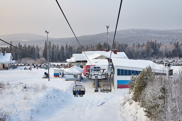 La gente practica snowboard y esquí, actividades invernales y deportes. Esquiar montaña abajo en una tabla de snowboard, emociones divertidas en los rostros de hombres y mujeres