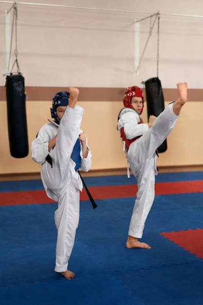 Foto gente practicando taekwondo en un gimnasio