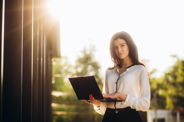 Gente profesional Concepto de conocimiento Mujer de negocios mano trabajando con computadora portátil con computadora cerca de edificio de oficinas moderno Concepto de tecnología Trabajo en línea Internet 4g