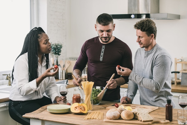 Gente de raza mixta cocinando en la cocina