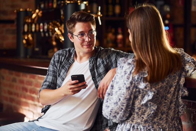 Gente con ropa informal sentada en el pub.