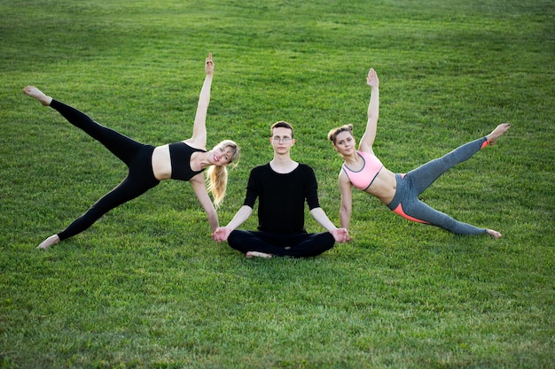 Gente sana madura haciendo yoga en el parque Grupo de personas haciendo ejercicio en la hierba verde