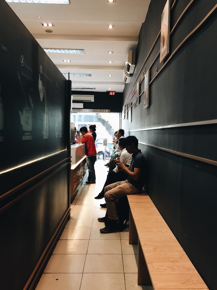 Foto gente sentada en un banco en una cafetería