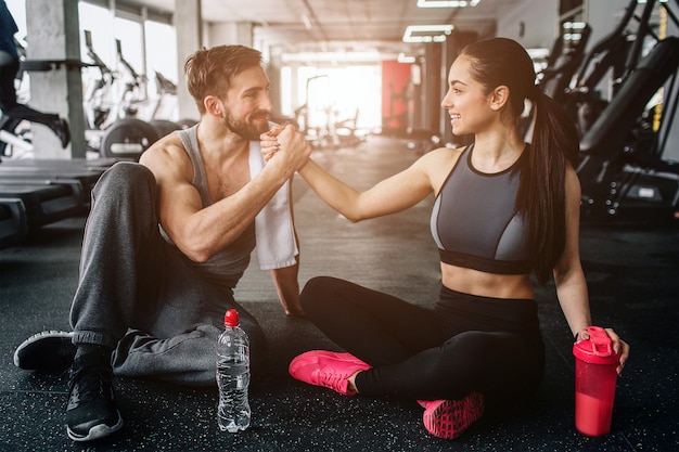 gente sentada en el piso en el gimnasio cerca uno del otro