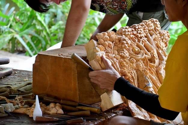 Gente tailandesa tallando una figura de madera de arte tailandés tradicional para mostrar al viajero en la ciudad antigua Muang Boran Samutprakarn en Samutprakarn Tailandia