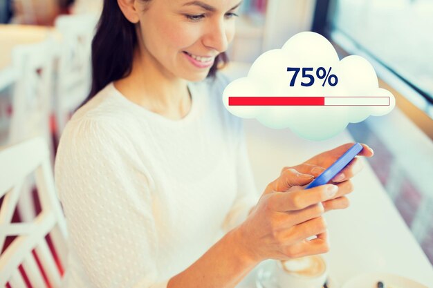 gente, tecnología y concepto de computación en la nube - cierre de una mujer feliz con smartphone compartiendo o cargando archivos en la oficina o en casa