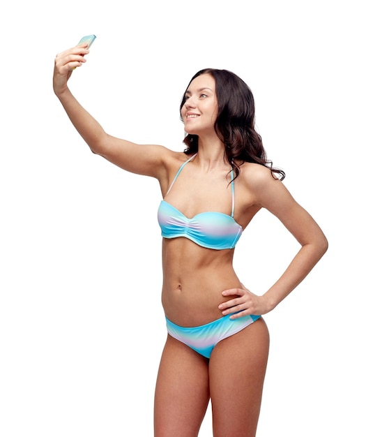 gente, tecnología, concepto de verano y playa - mujer joven feliz en traje de baño bikini tomando selfie con smatphone