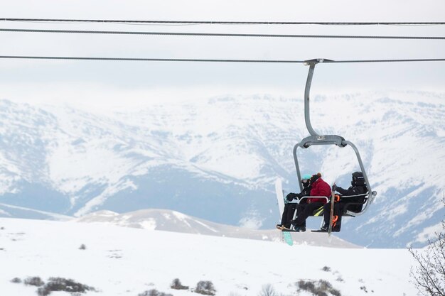 Gente en un teleférico sube por una pista de esquí