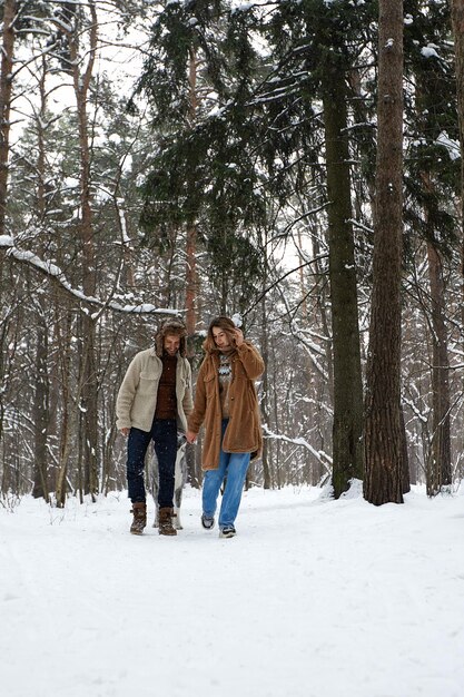 Gente temporada amor y ocio concepto feliz pareja abrazándose y riendo al aire libre en invierno Pareja abrazándose y divirtiéndose en el parque de invierno cubierto de nieve