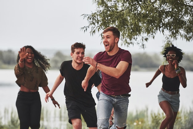 La gente tiene fiesta afuera. Los amigos multiétnicos se reúnen los fines de semana.