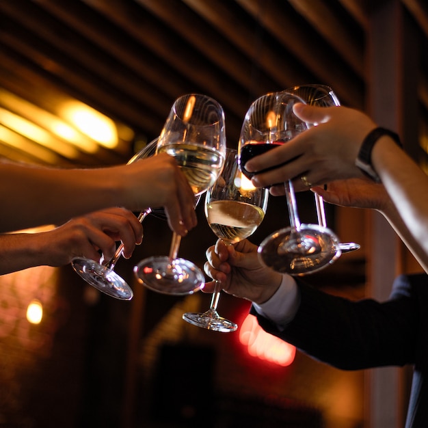 Gente tintineando copas de vino en el restaurante