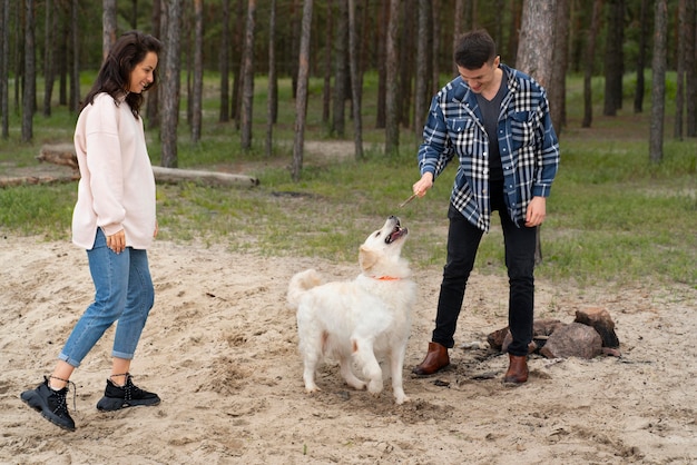 Foto gente de tiro completo jugando con perro