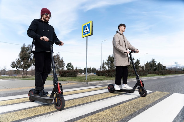 Gente de tiro completo en scooters eléctricos.