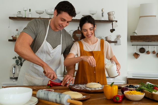 Foto gente de tiro medio cocinando pizza juntos