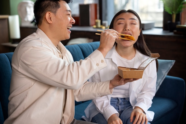 Gente de tiro medio comiendo comida asiática.