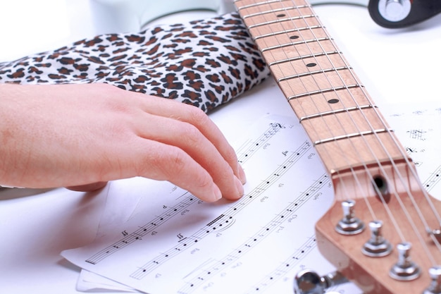 Gente tocando guitarra con acordes musicales en cuarto oscuro