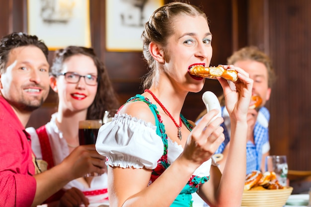 Gente en Tracht bávaro comiendo en restaurante o pub