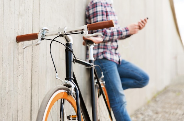 gente, transporte, ocio y estilo de vida - cerca de la bicicleta de piñón fijo hipster y el hombre en la calle de la ciudad