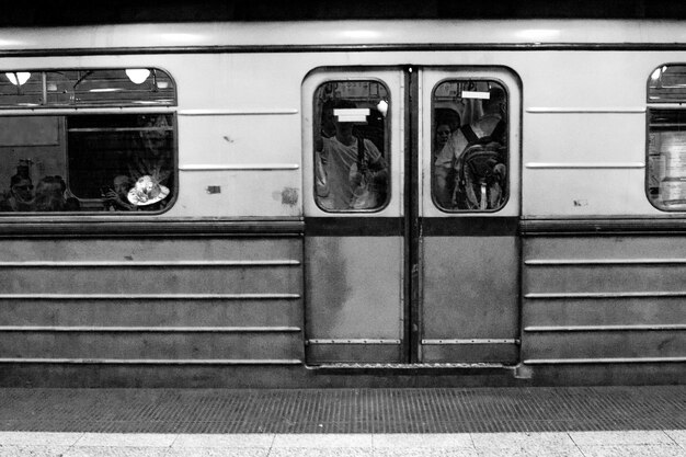 Foto gente en el tren vista a través de una ventana de vidrio