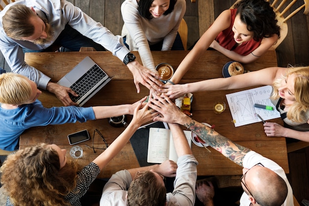 La gente une las manos como un trabajo en equipo