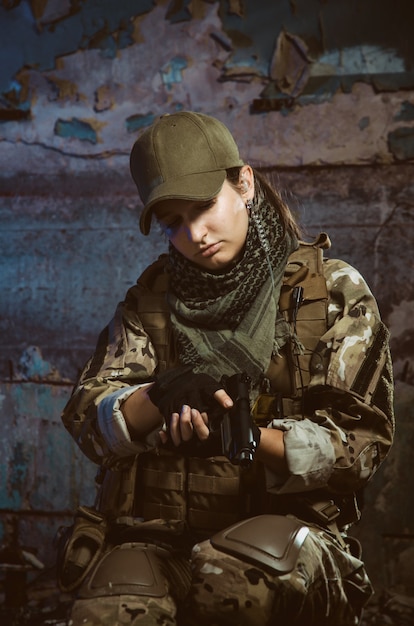 La gente de uniforme con armas en las ruinas.