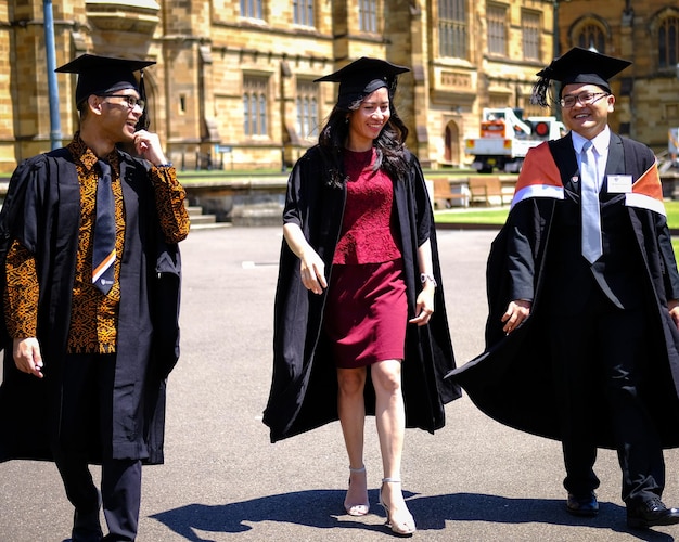 Foto gente con vestido de graduación caminando por la calle