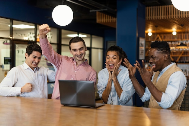 Foto gente victoriosa siendo feliz durante una videollamada en el trabajo