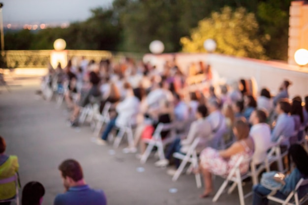 gente viendo escuchar un concierto de una banda clásica a la luz del día ambiente al aire libre foto borrosa