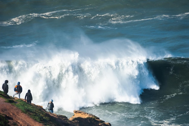 Gente viendo grandes olas en Nazaré, Portugal. La temporada de grandes olas dura aquí de noviembre a marzo.