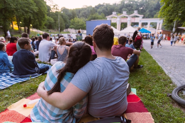 Gente viendo películas en cine al aire libre en el parque de la ciudad