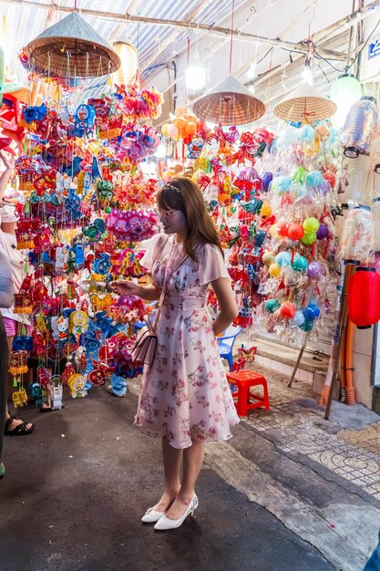 La gente visita y compra coloridas linternas tradicionales colgando durante el Festival de Medio Otoño