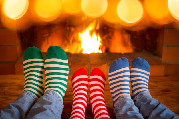 gente vistiendo calcetines de navidad cerca de la chimenea