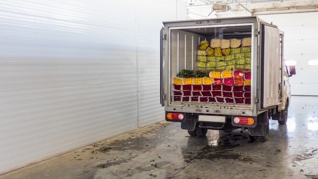 Geöffnete Hintertüren des mit Rosenblüten beladenen Lastwagens. Laden von Blumen auf Lager für die Lieferung.