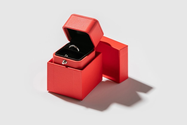 Geöffnete kleine Geschenkbox aus rotem Papier, mit Verlobungsring drin