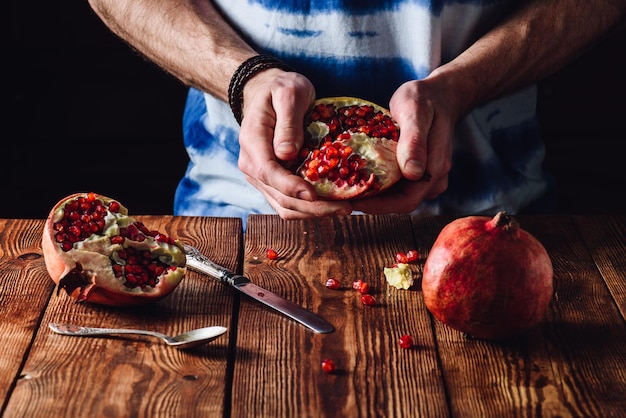 Geöffneter Granatapfel in den Händen