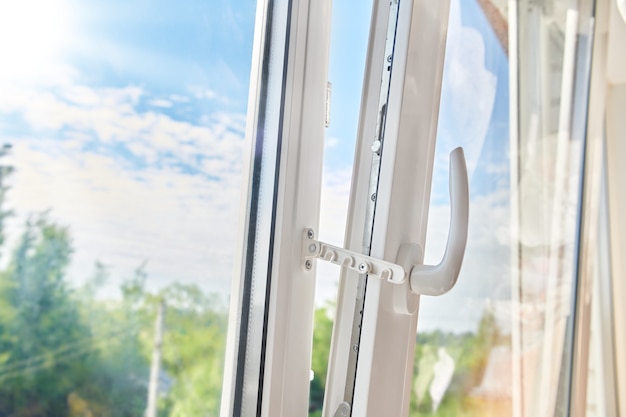 Geöffneter Kunststofffensterrahmen. Fenstermontage aus Kunststoff. Wohnungslüftung durch Fenster. Sonniger Morgen vor dem weißen Plastikfenster.