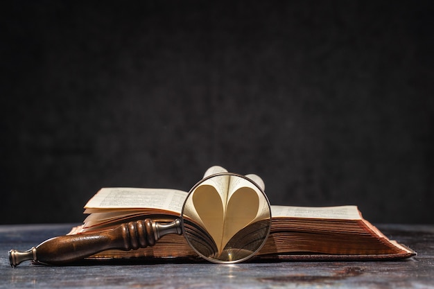 Geöffnetes altes Buch mit Herz aus zwei Seiten. Offene Seiten bilden ein Herz, ein Symbol der Liebe