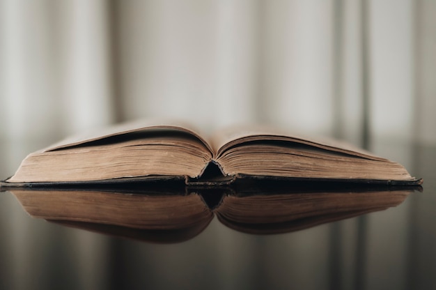 Foto geöffnetes altes buch mit reflektierter brauner oberfläche