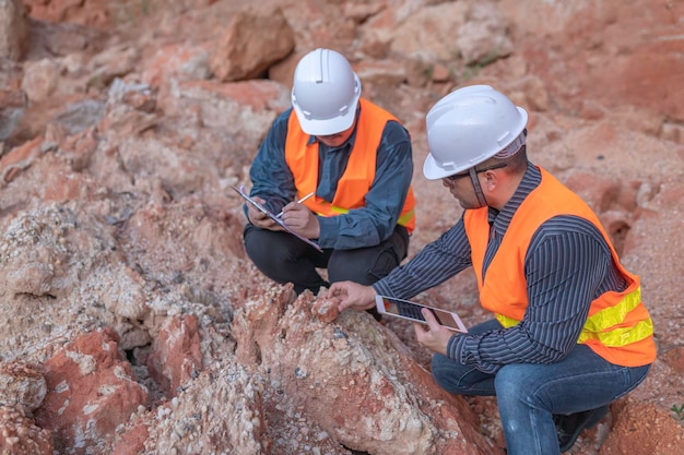 Foto geologe bei der vermessung von minen entdecker sammeln bodenproben, um nach mineralien zu suchen