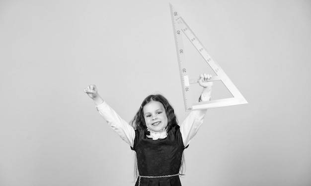 Foto geometría de estudio de estudiante de escuela regla de retención de uniforme escolar para niños concepto de educación escolar aprender matemáticas teoremas y axiomas concepto inteligente e inteligente dimensionamiento y medición chica con regla grande