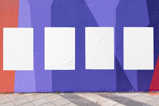 Geometrische Wand und vier weiße geklebte, runzelige Postervorlagen